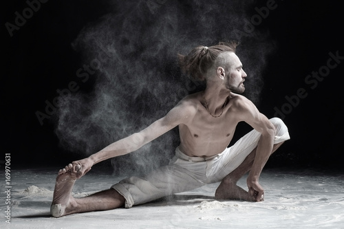 Flexible yoga man doung wide side lunge or utthita namaskarasana.
