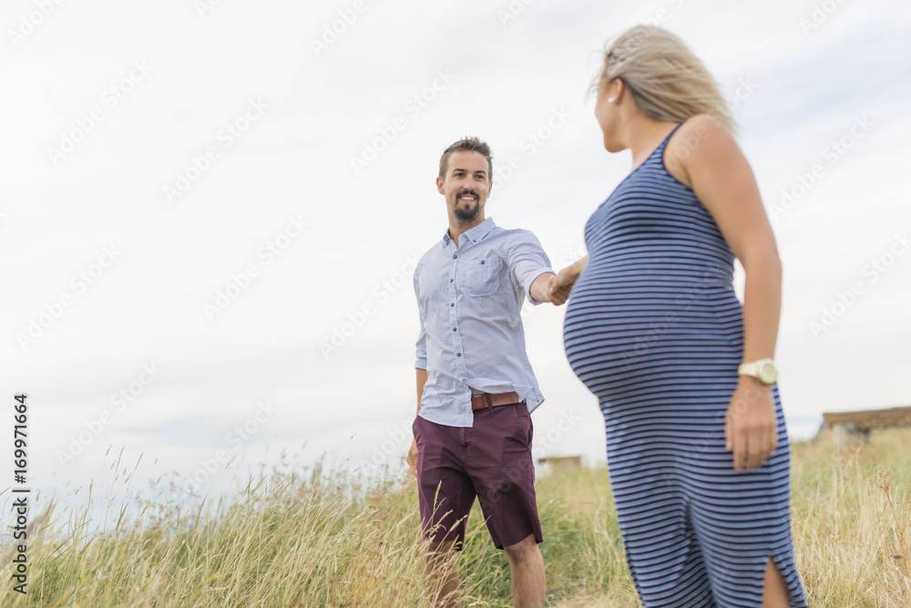 pregnant woman at beach with husband having fun