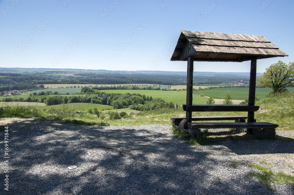 Romantic wooden tourists shelter with seats and table on viewpoint, beautiful landscape, Stremosice, Czech republic