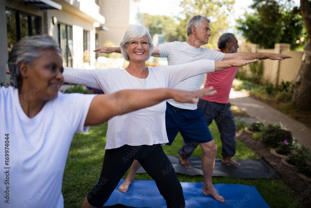 Smiling senior woman exercising with friends at park