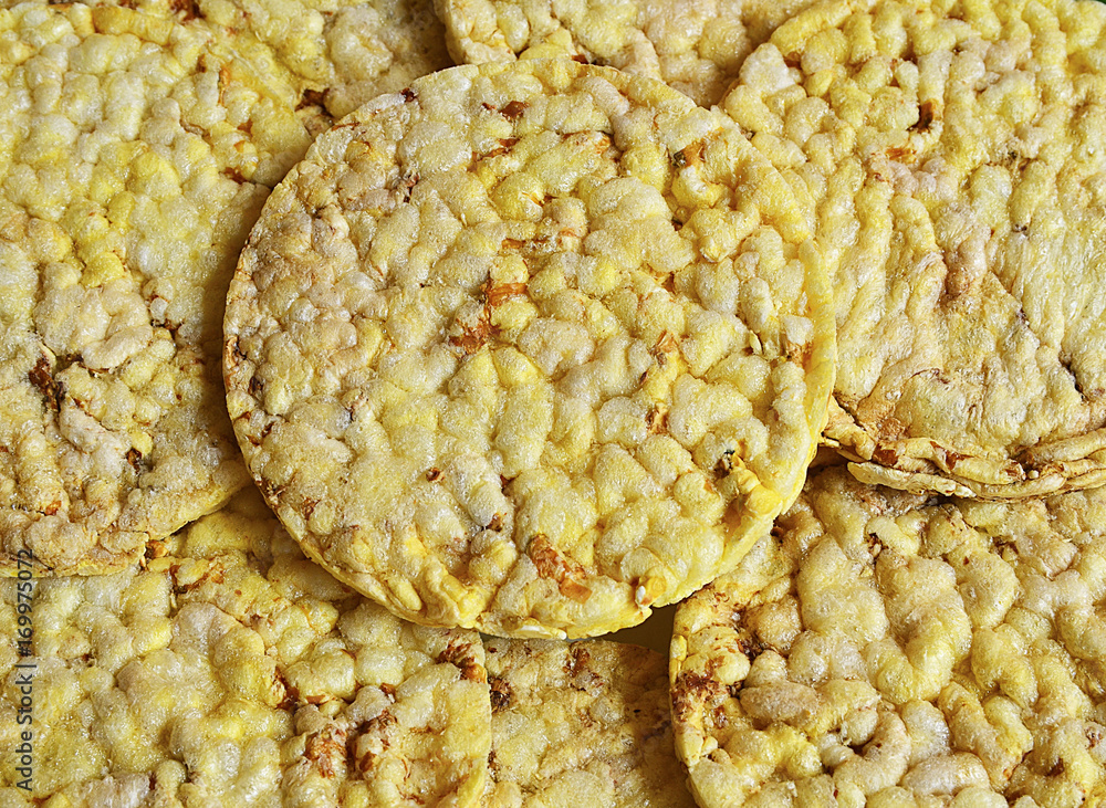 Grain crispbreads close up macro as a background.Stack of puffed whole grain crispbread.Rice cake puffed rice texture.Round rice cakes background.Corn crackers. Rice galettes.Selective focus. Grain crispbreads close up macro as a background.Stack of puffed whole grain crispbread.Rice cake puffed rice texture.Round rice cakes background.Corn crackers. Rice galettes.Selective focus.