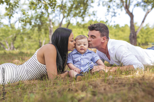 Happy Family Having fun with baby playing In The Park.