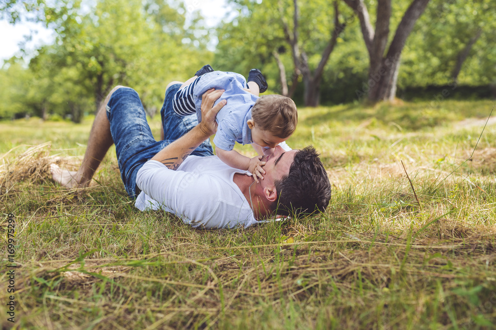 beautiful father little toddler son on the meadow. beautiful father little toddler son on the meadow.