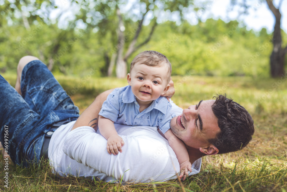 beautiful father little toddler son on the meadow. beautiful father little toddler son on the meadow.