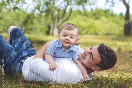 beautiful father little toddler son on the meadow.