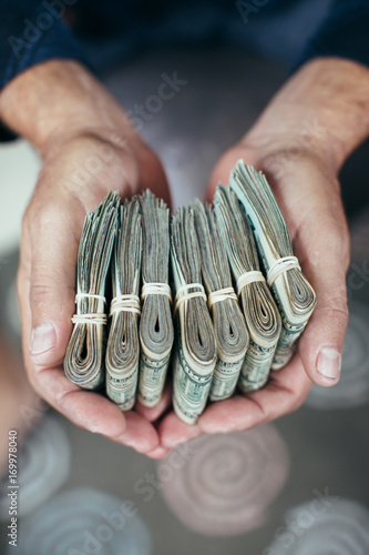 Close-up of a man's hand holding bundle of a cash