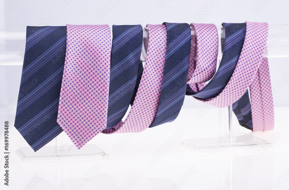 Pink and blue ties twisted around the pole. White background. Pink and blue ties twisted around the pole. White background.