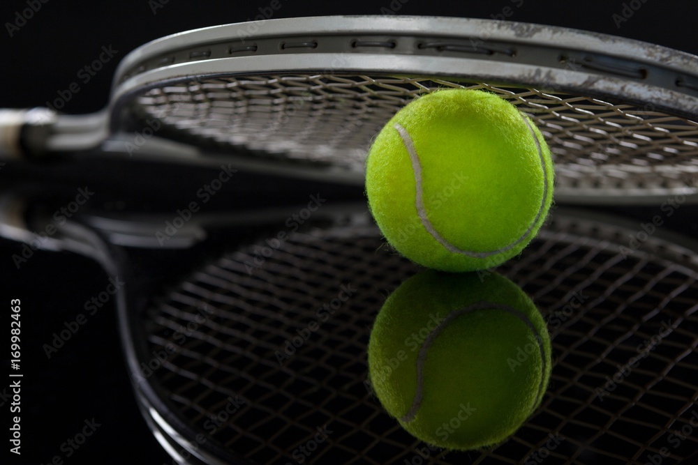 Close up of racket on fluorescent yellow tennis ball with