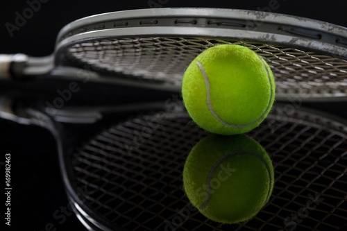 Close up of racket on fluorescent yellow tennis ball with © WavebreakMediaMicro