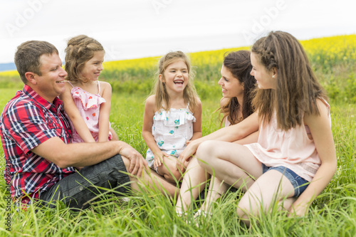 Family outdoors on a yellow field © Louis-Photo
