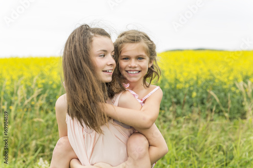beautiful girls in a field of yellow flowers © Louis-Photo