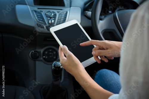 Woman using digital tablet in the car