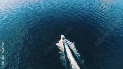 Bird eye view of luxurious speed boat sailing on the turquoise lake. It perfectly describes traveling to new amazing destinations and summer vacation on the lake