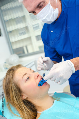 dentist examining his female patients mouth