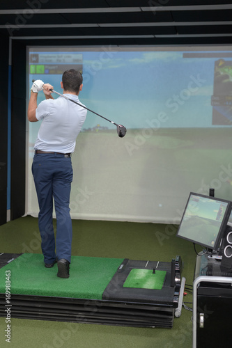 Bild auf Leinwand young man playing virtual golf game