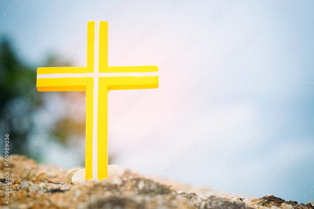 Concept conceptual yellow cross religion symbol in nature over sunset or sunrise sky