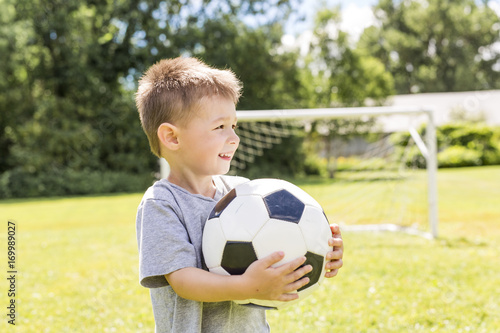 Portrait of young boy with soccer ball