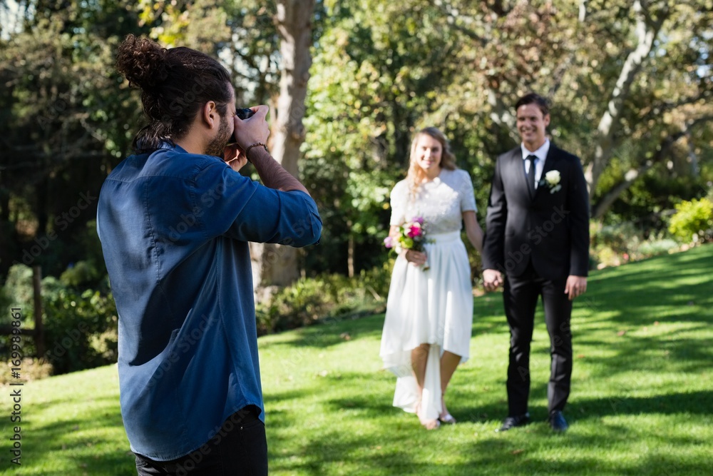 Photographer taking photo of newly married couple Photographer taking photo of newly married couple