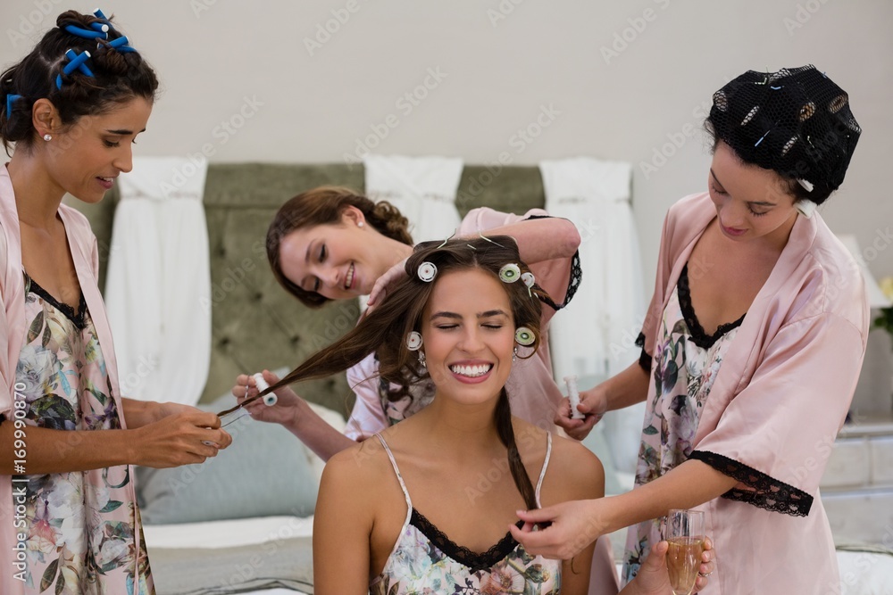 © WavebreakMediaMicro - Bridesmaid assisting bride in getting ready