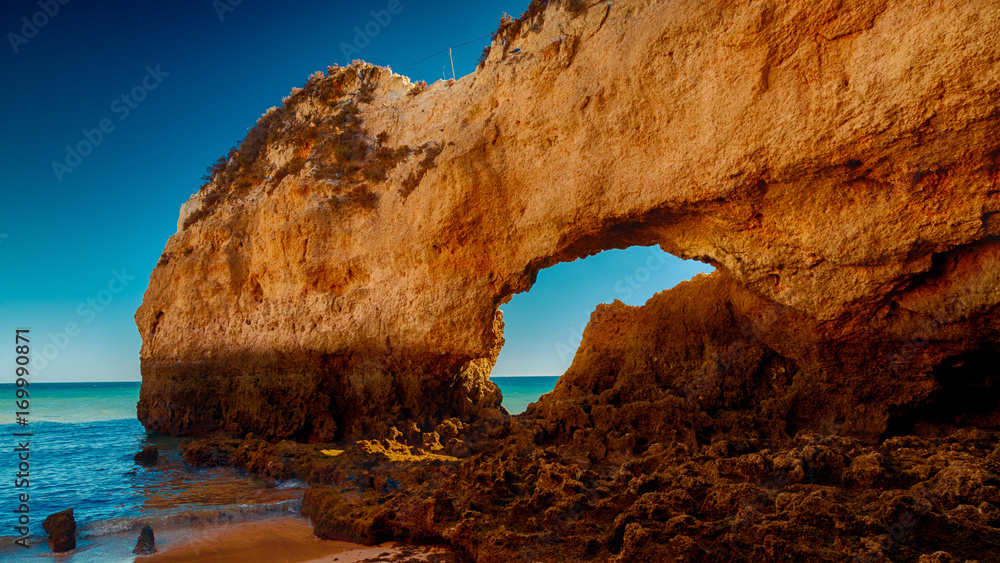 THE ALGARVE, circa 2016 - Telephoto shot of a large rock formation in the Praia da Rocha beach, The Algarve, Portugal