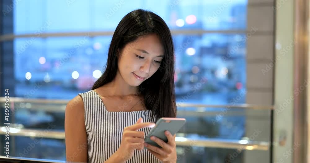 Woman looking at mobile phone in shopping mall Woman looking at mobile phone in shopping mall