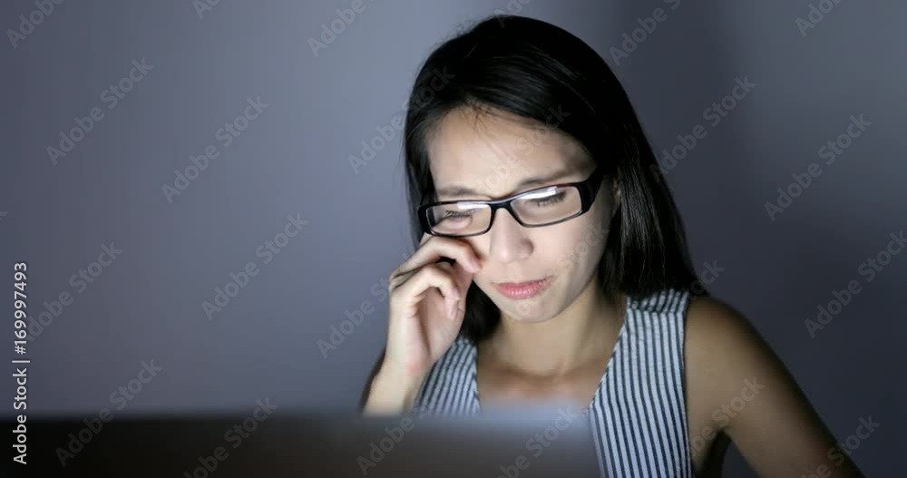 Woman feeling eye pain and using laptop computer at home Woman feeling eye pain and using laptop computer at home