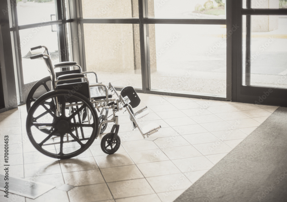 Solitary wheelchair resting in the lobby of a hospital. Abstract healthcare and disability image Solitary wheelchair resting in the lobby of a hospital. Abstract healthcare and disability image