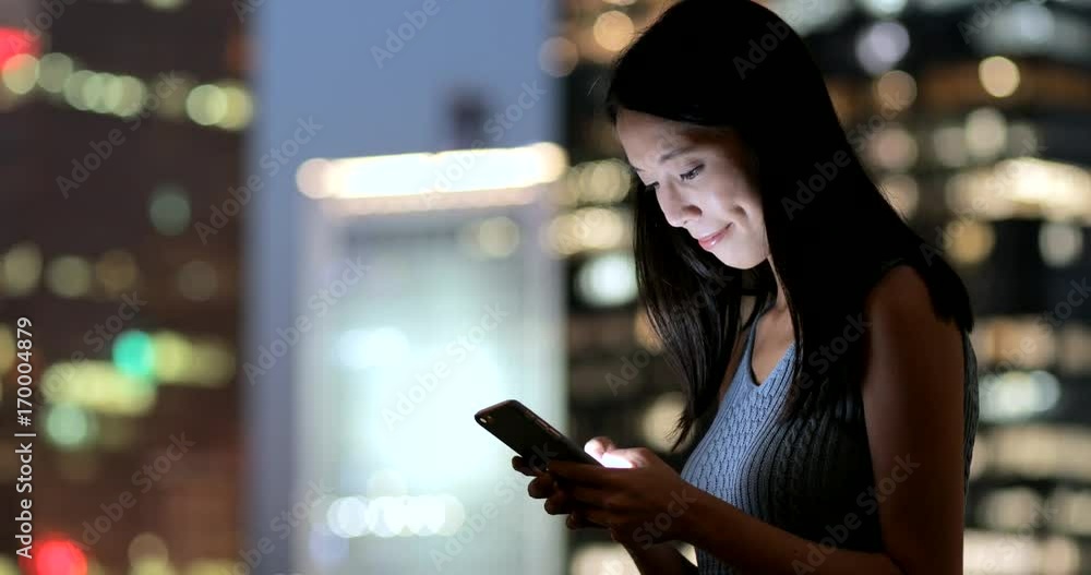 Business woman use of smart phone in the city at night Business woman use of smart phone in the city at night