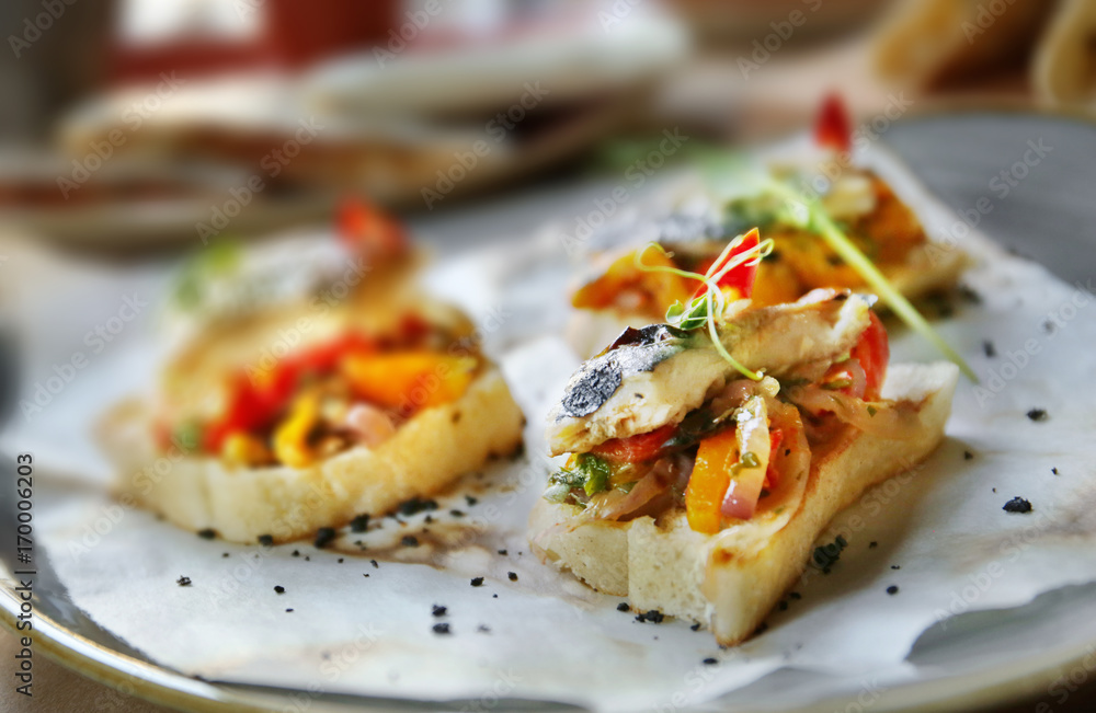 Delicious molletes with fillet of fish and vegetables on plate