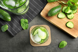 Delicious refreshing water with mint and cucumber in glass on table