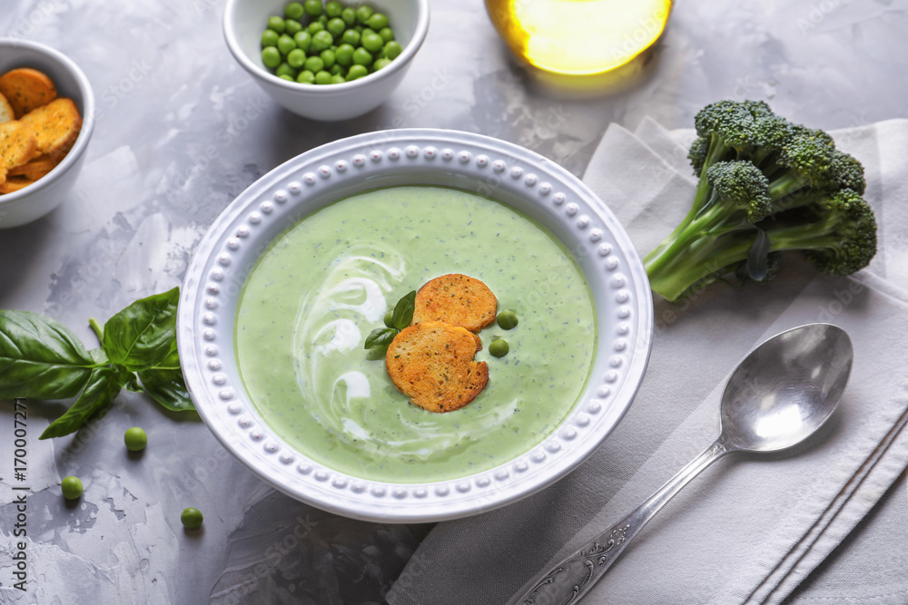 Bowl with tasty broccoli soup on grey background Bowl with tasty broccoli soup on grey background