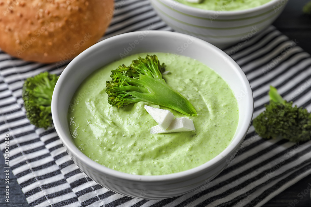 Bowl with delicious broccoli soup on table