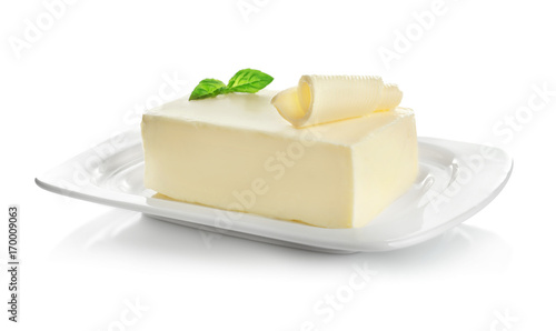 Plate with piece of butter on white background