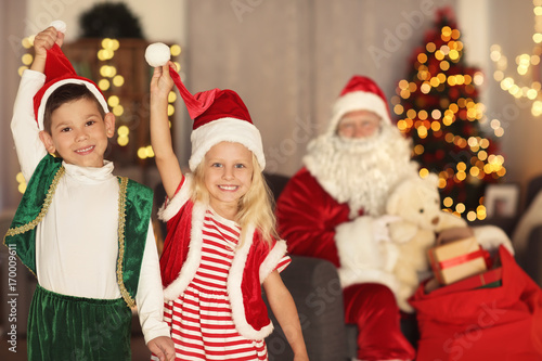 Cute elf kids in room beautifully decorated for Christmas