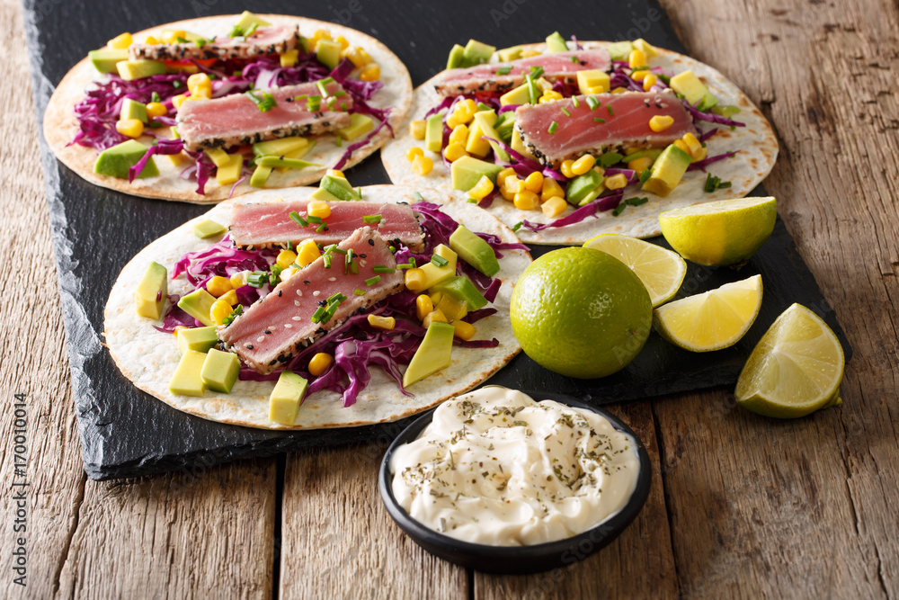 Φωτογραφία Delicious fish takos with fried tuna fillets, corn, red cabbage, lime and avocado close-up