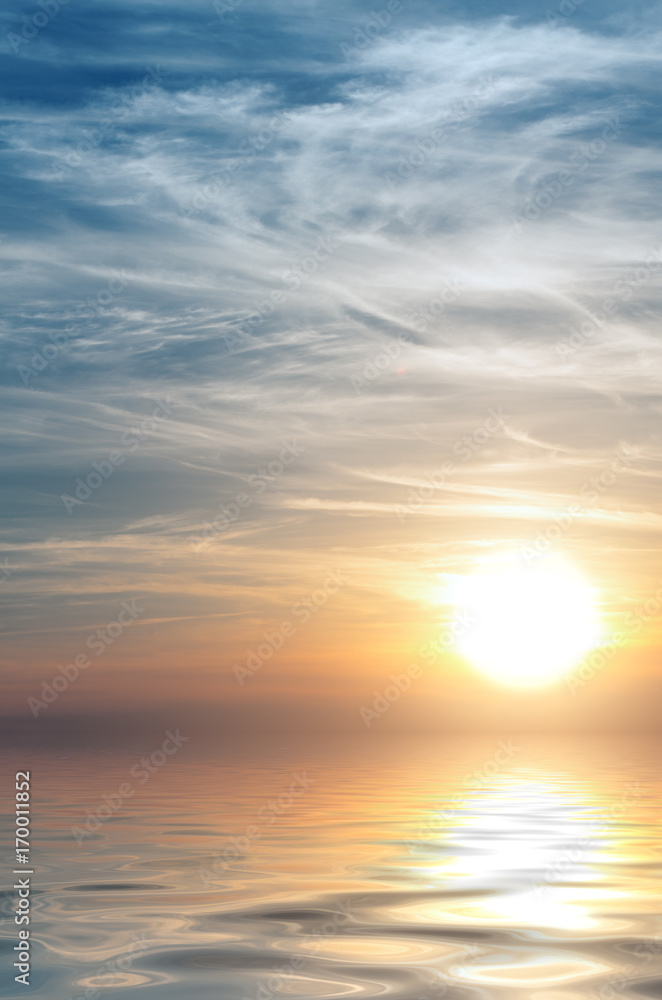 A huge sun at sunset against the background of cirrus clouds and the sea.