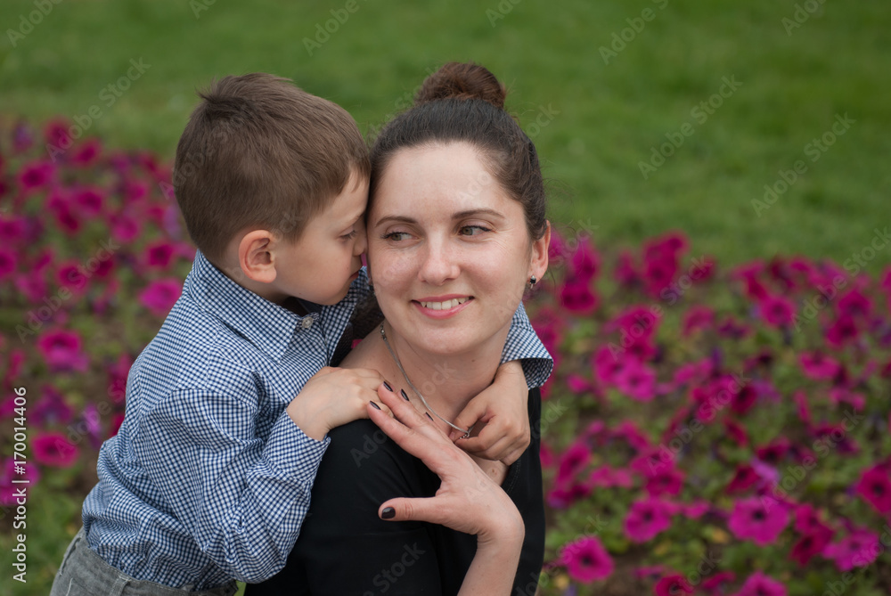adorable little boy kisses his happy mother adorable little boy kisses his happy mother