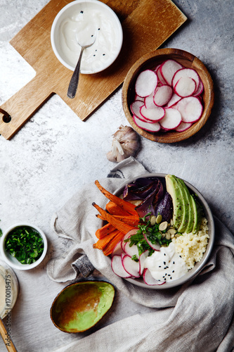 Wallpaper Mural Fresh healthy vegetarian bowl for lunch with baked carrots and red onion, coucous and sliced avocado. Simple and colourful organic food concept. Vertical flat lay with copy space. Torontodigital.ca