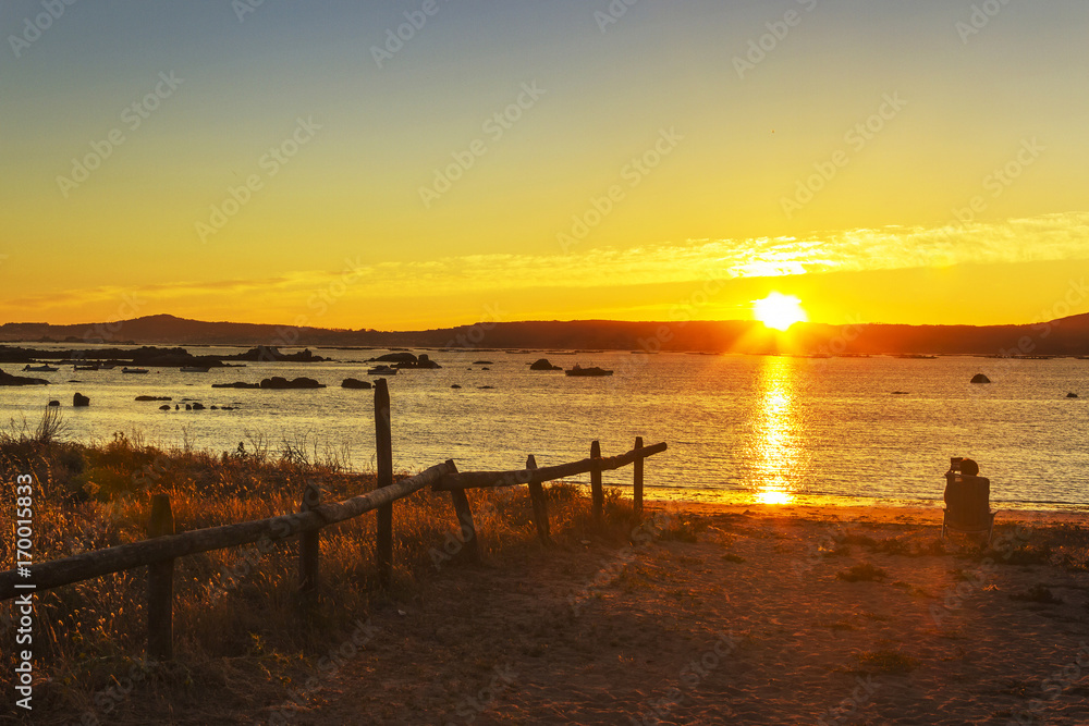 Fenced coastal dune at sunset