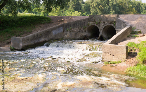 stone pond drainage with small waterfall. background, nature.