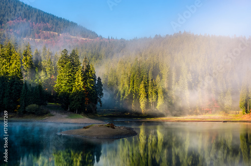 mountainous lake in foggy forest