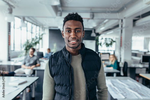 African male designer standing in modern office photo