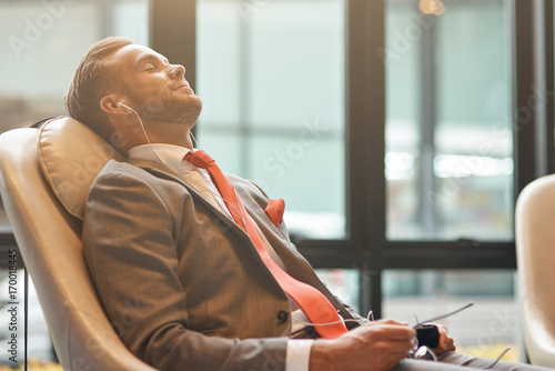 Professional businessman having a nap in the departure lounge