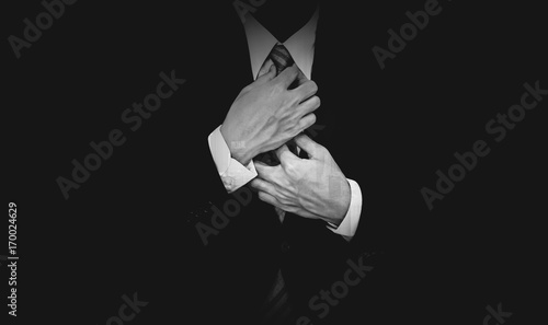 Businessman in black suit on black background, black and white photo