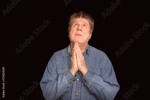 Portrait of a religious expressive man praying in studio photo