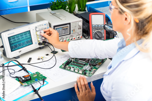 Female electronic engineer using oscilloscope in laboratory photo