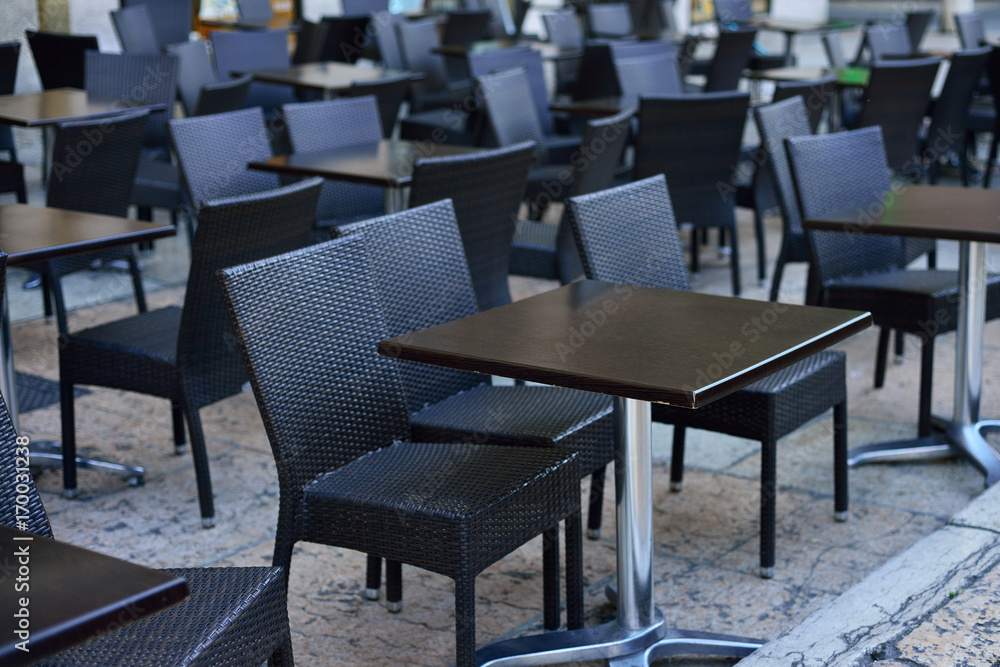 Black tables and chairs in the restaurant before opening. An empty restaurant.