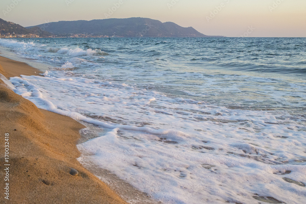 Panorama di un tratto di costa in prossimità di Santa Maria di Castellabate. Il mare è pulito ma agitato e le onde scontrandosi con la sabbia della spiaggia formano la schiuma bianca. Panorama di un tratto di costa in prossimità di Santa Maria di Castellabate. Il mare è pulito ma agitato e le onde scontrandosi con la sabbia della spiaggia formano la schiuma bianca.