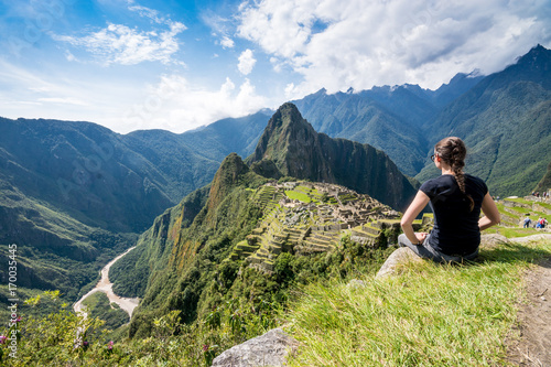 Frau blickt auf die Inka-Ruinen von Machu Picchu