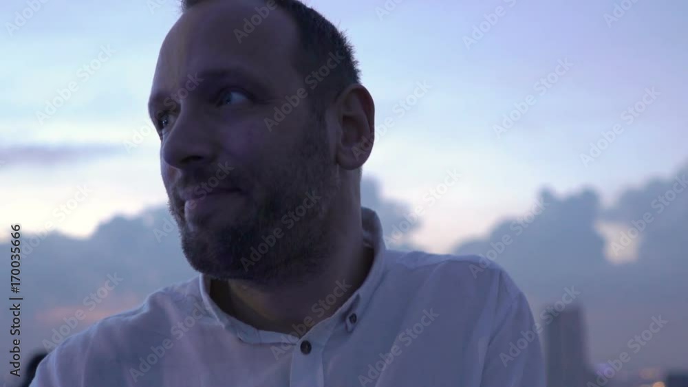 Young, happy man drinking cocktail standing on terrace in bar
Young, happy man drinking cocktail standing on terrace in bar